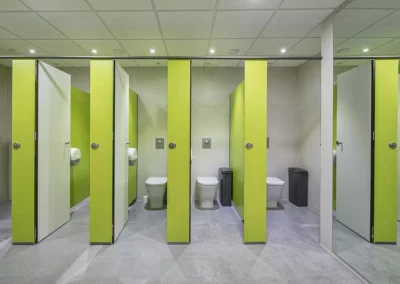 Cabinas de cuarto de baño con acabado en verde en las oficinas de Endesa 2