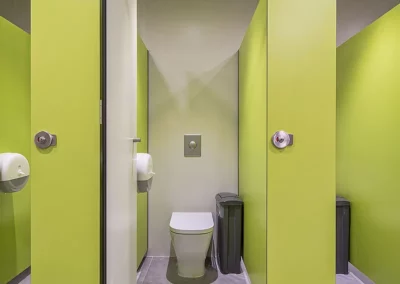 Cabinas de cuarto de baño con acabado en verde en las oficinas de Endesa