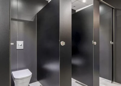 Cabinas fenólicas en acabado madera oscura para los baños de Endesa