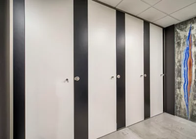 Cabinas con separadores oscuros y puertas blancas